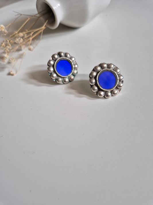 Blue and silver stud earrings, artistic close-up
