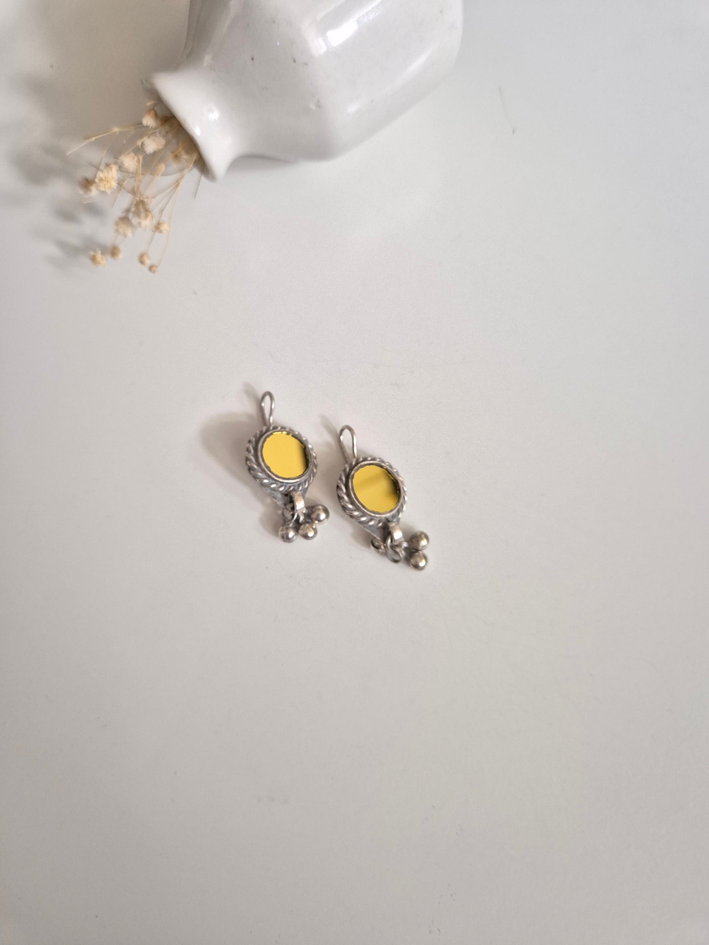Silver and yellow glass dangle earrings standing upright