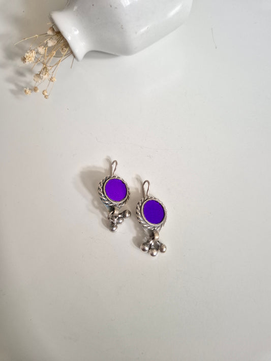 Deep-tone metal and glass earrings, close-up on unique shape