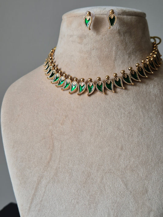 Handcrafted golden necklace set with green stones on neutral background, classic style