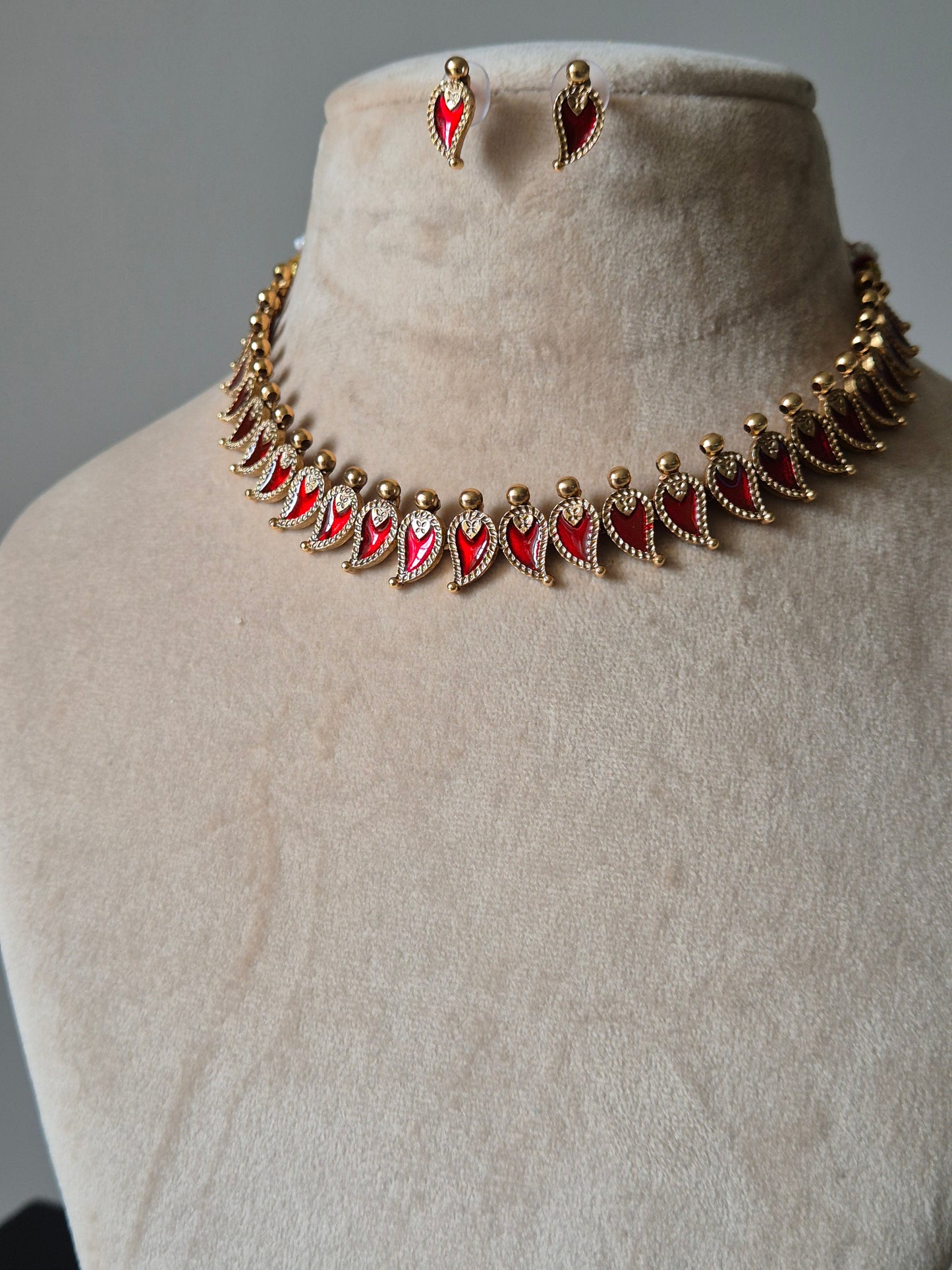 Gold and red necklace set, Aja by Naitri, displayed with matching earrings.