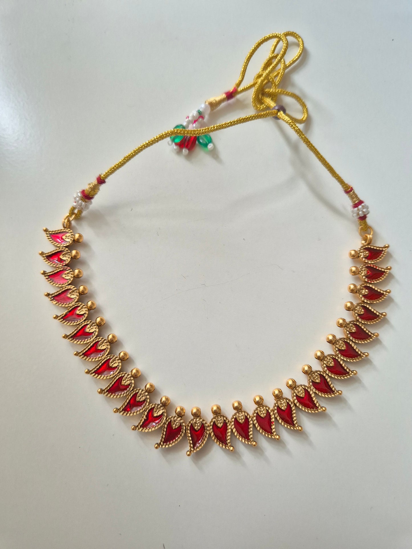 Gold and red necklace set, Aja by Naitri, displayed with matching earrings.