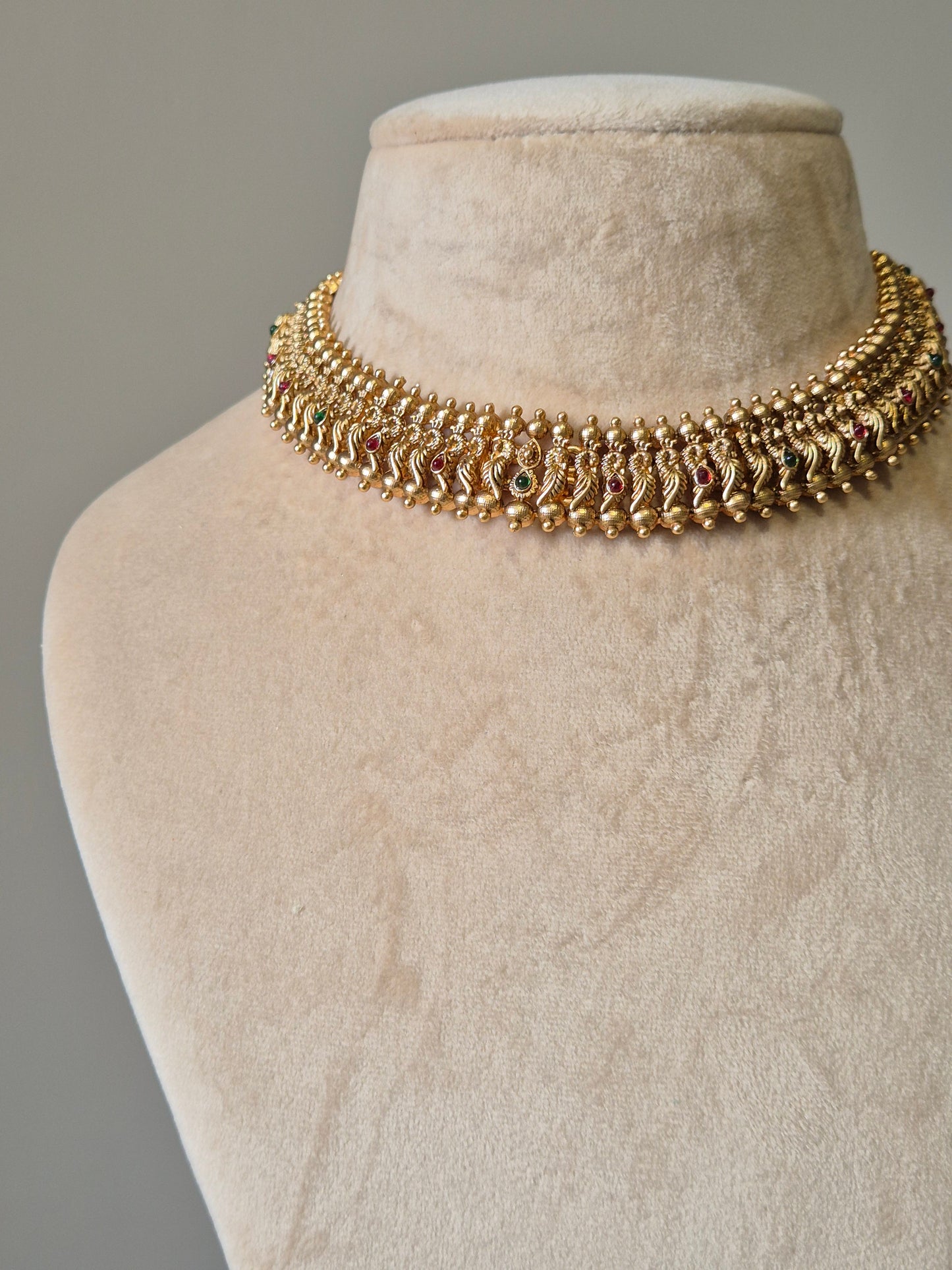 Gold necklace set with red stones, Lipsa by Naitri, classic design shown flat.