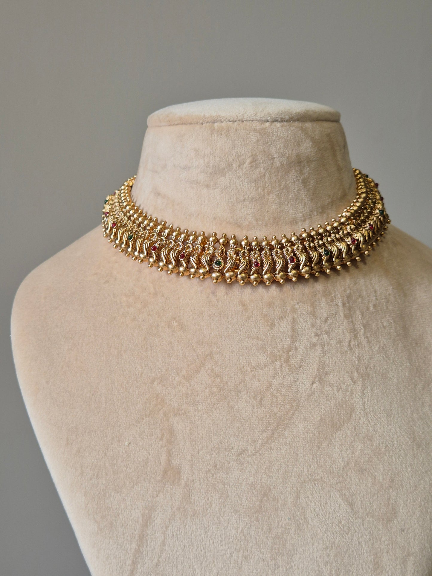 Gold necklace set with red stones, Lipsa by Naitri, classic design shown flat.