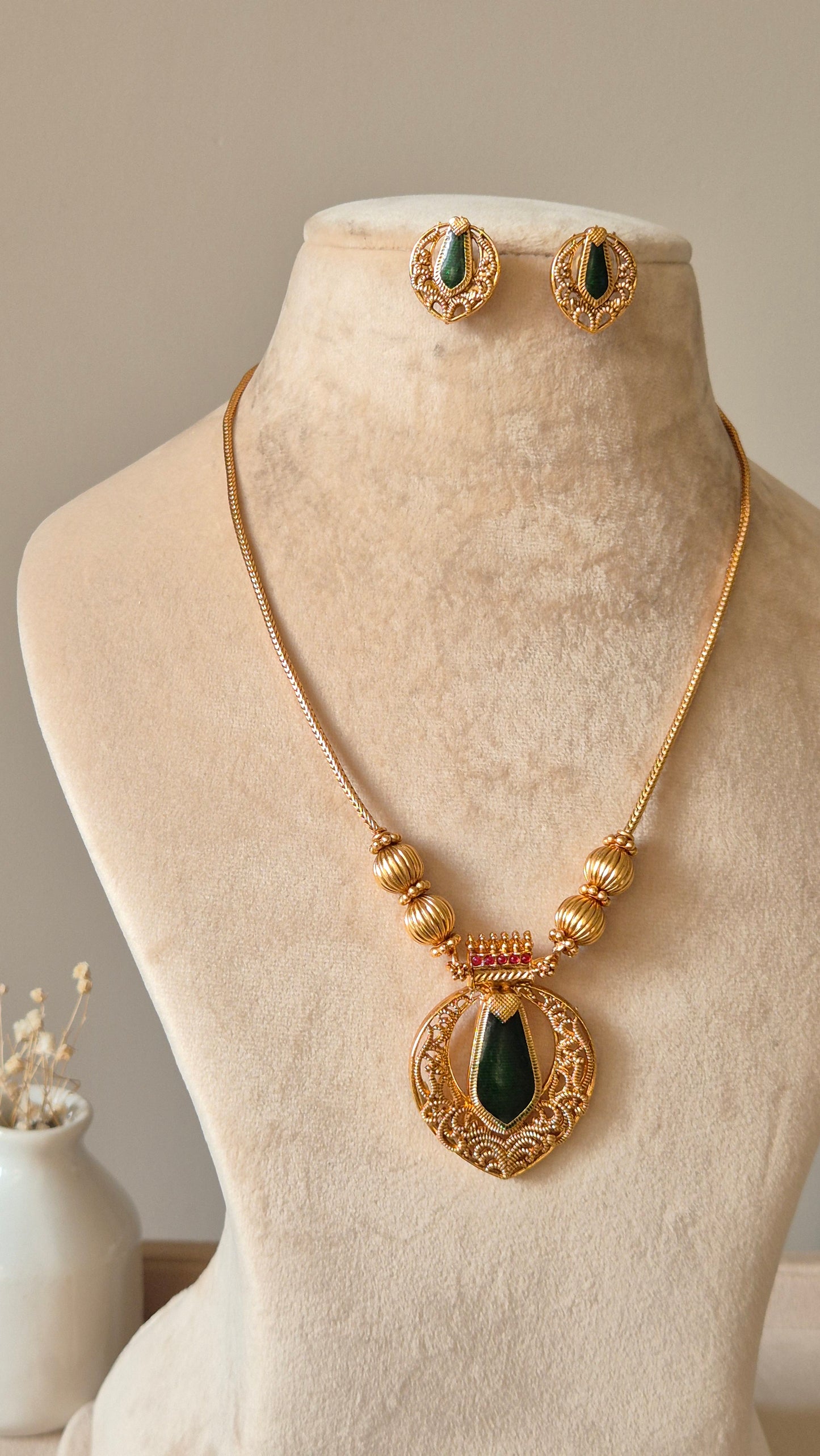 Red and gold necklace set, Angika by Naitri, displayed with matching earrings.
