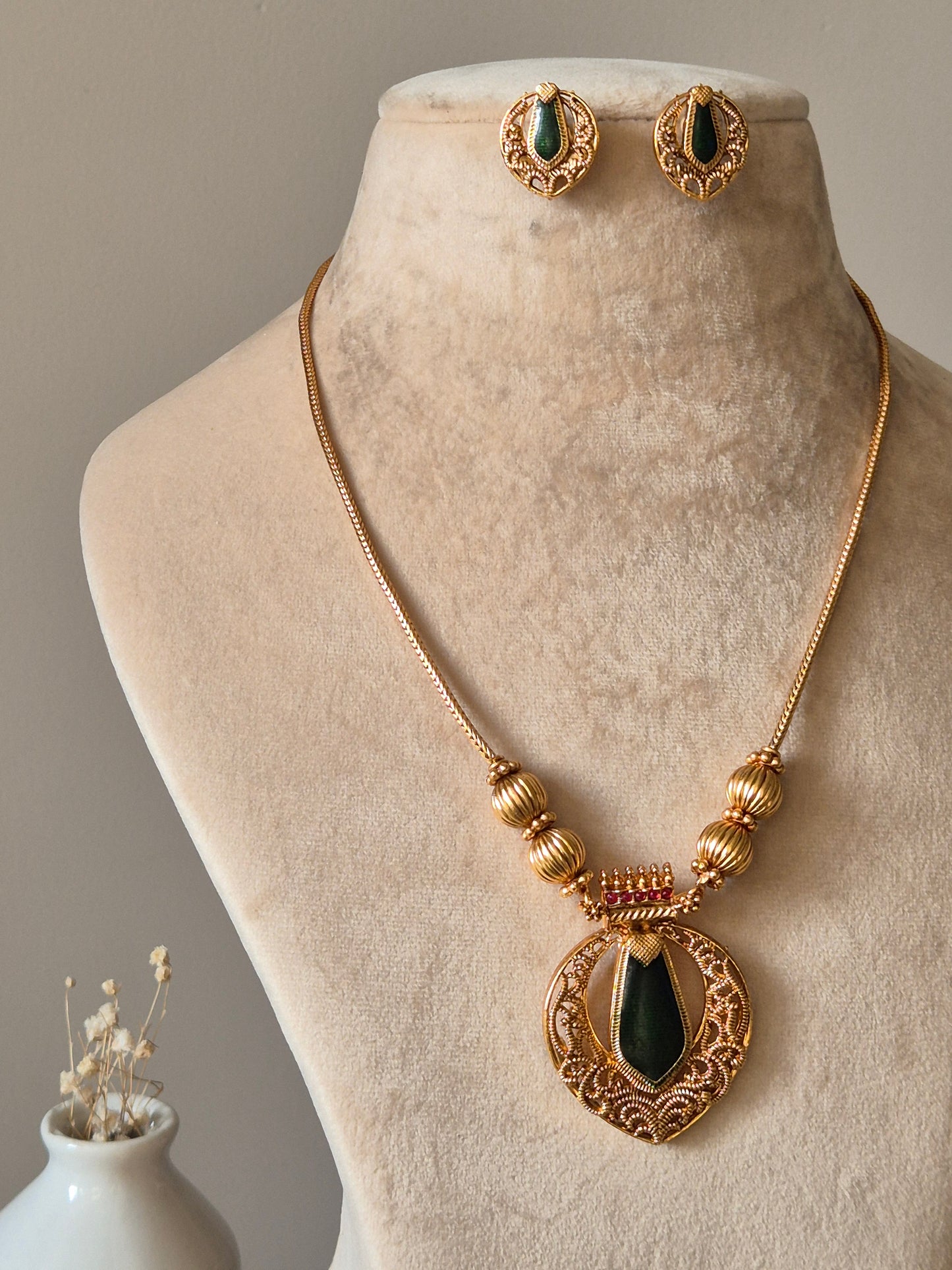 Red and gold necklace set, Angika by Naitri, displayed with matching earrings.