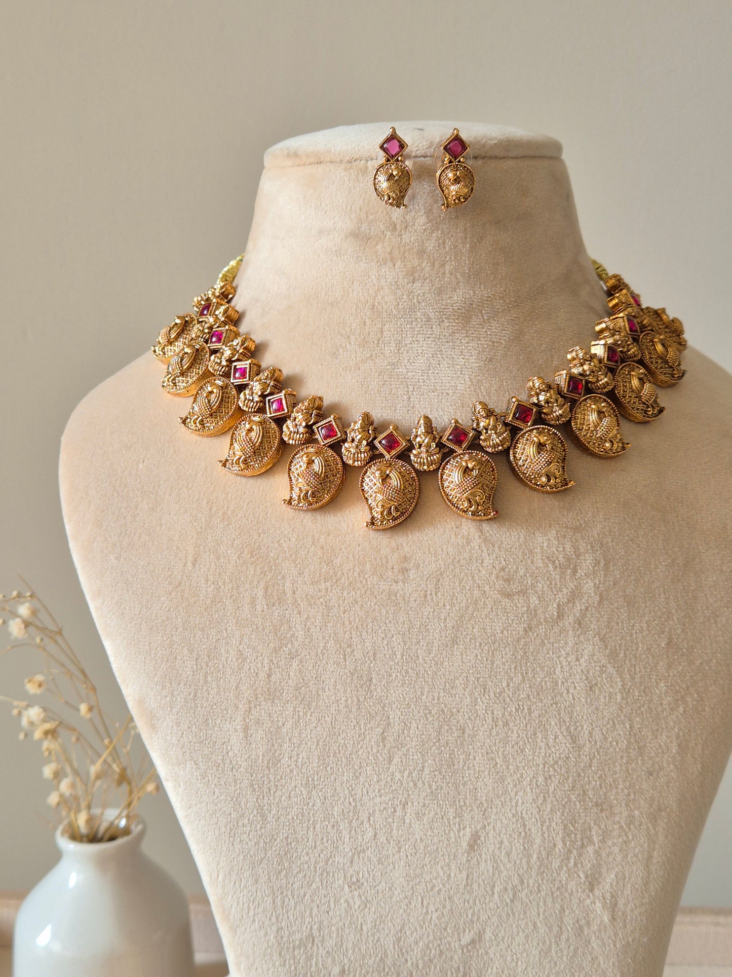 Gold necklace set with matching earrings, Nimai by Naitri, displayed on fabric.