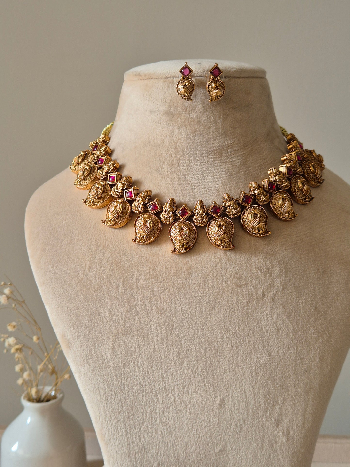 Gold necklace set with matching earrings, Nimai by Naitri, displayed on fabric.