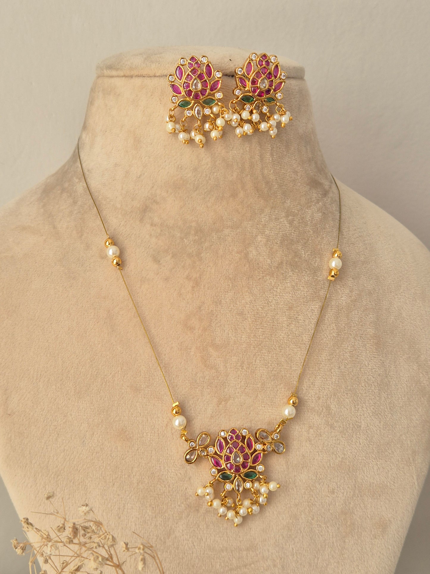 Ludhika Necklace Set gold lotus floral pendant with pink and green stones, pearl drops, and matching earrings by Naitri