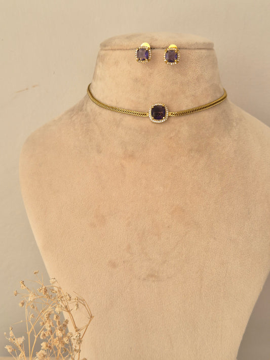Traditional Indian long mangalsutra set in an antique gold finish, featuring an intricately carved centerpiece pendant accented with ruby-pink drop stones on a dual black-beaded chain, paired with matching round stud earrings