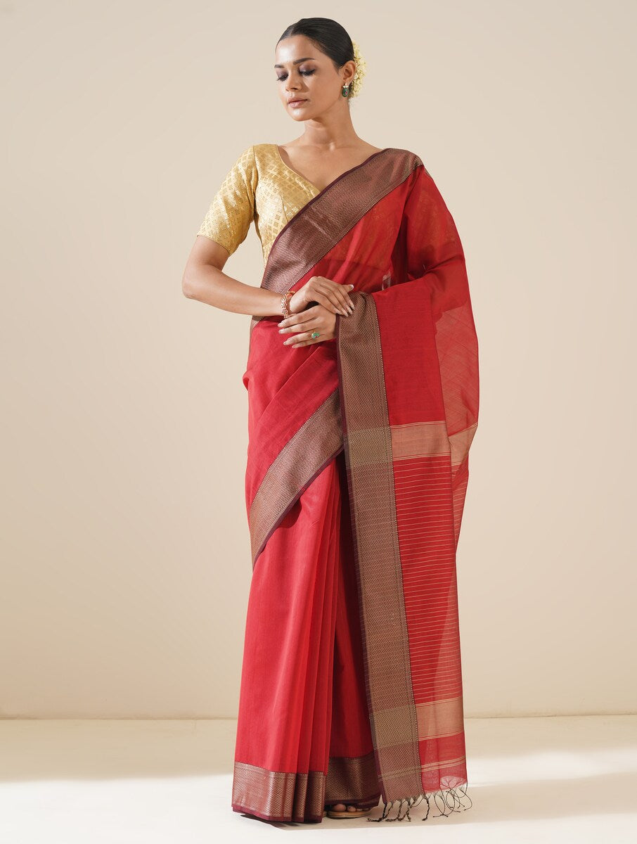 Elegant red Maheshwari saree displayed with matching blouse, emphasizing fabric detail and weave