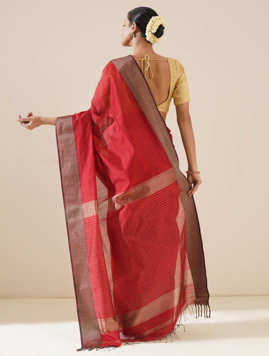 Elegant red Maheshwari saree displayed with matching blouse, emphasizing fabric detail and weave