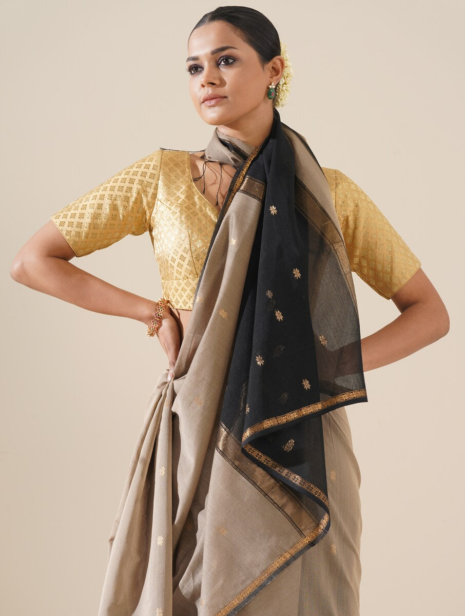 Beautiful grey and black saree draped on mannequin highlighting traditional craftsmanship and silk texture
