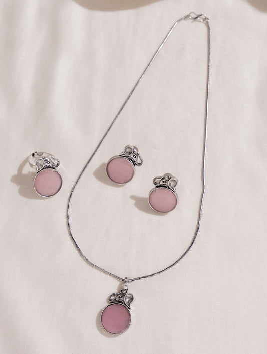 Pink and silver necklace, earrings, ring set on soft background