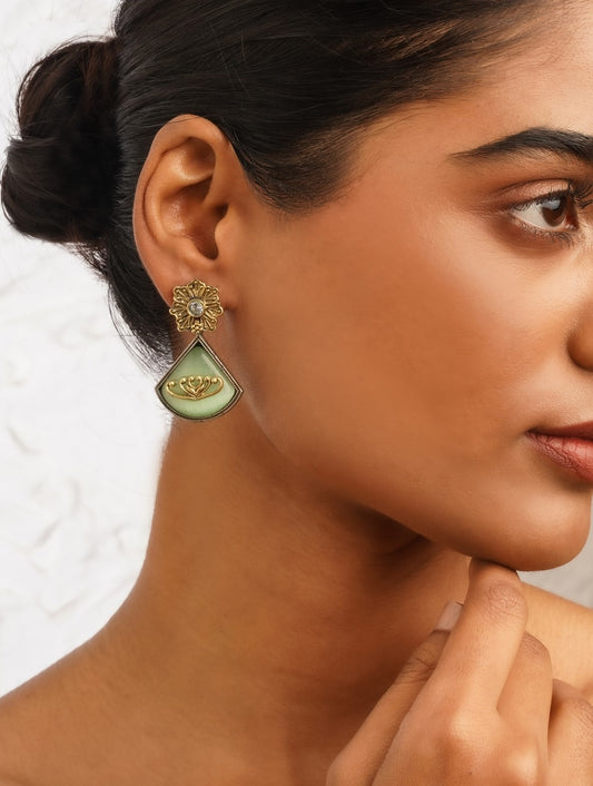 Dual-tone green and red brass dangle earrings on minimalist backdrop