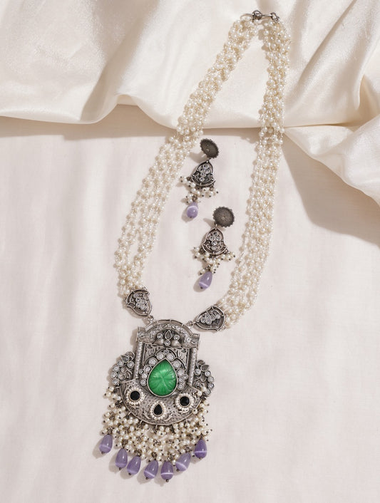 Gold, white, silver beaded necklace set laid out on dark background