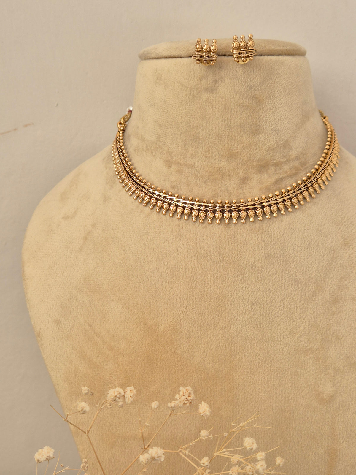 Detailed close-up of textured gold necklace by naitri.in