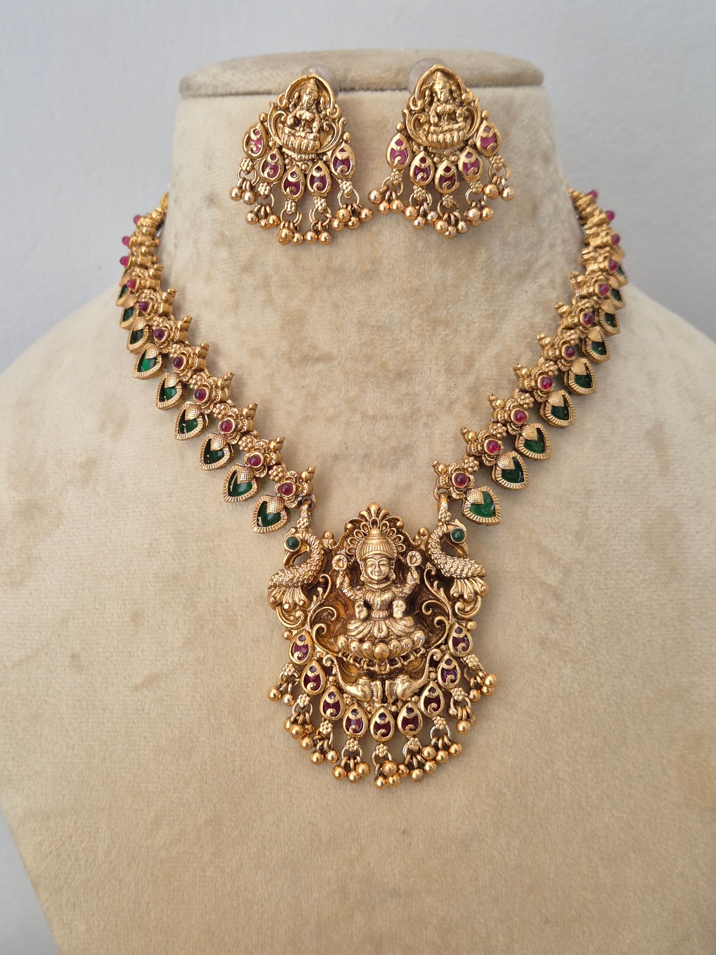 Elegant traditional gold-toned ethnic necklace set with intricate religious motif carvings, by naitri.in