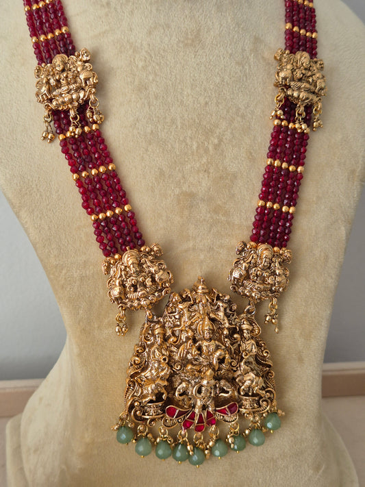 Modern Indian ethnic imitation jewelry set including a multi-layered ruby-red beaded strand necklace, a detailed gold temple pendant with hanging green beads, by naitri.in