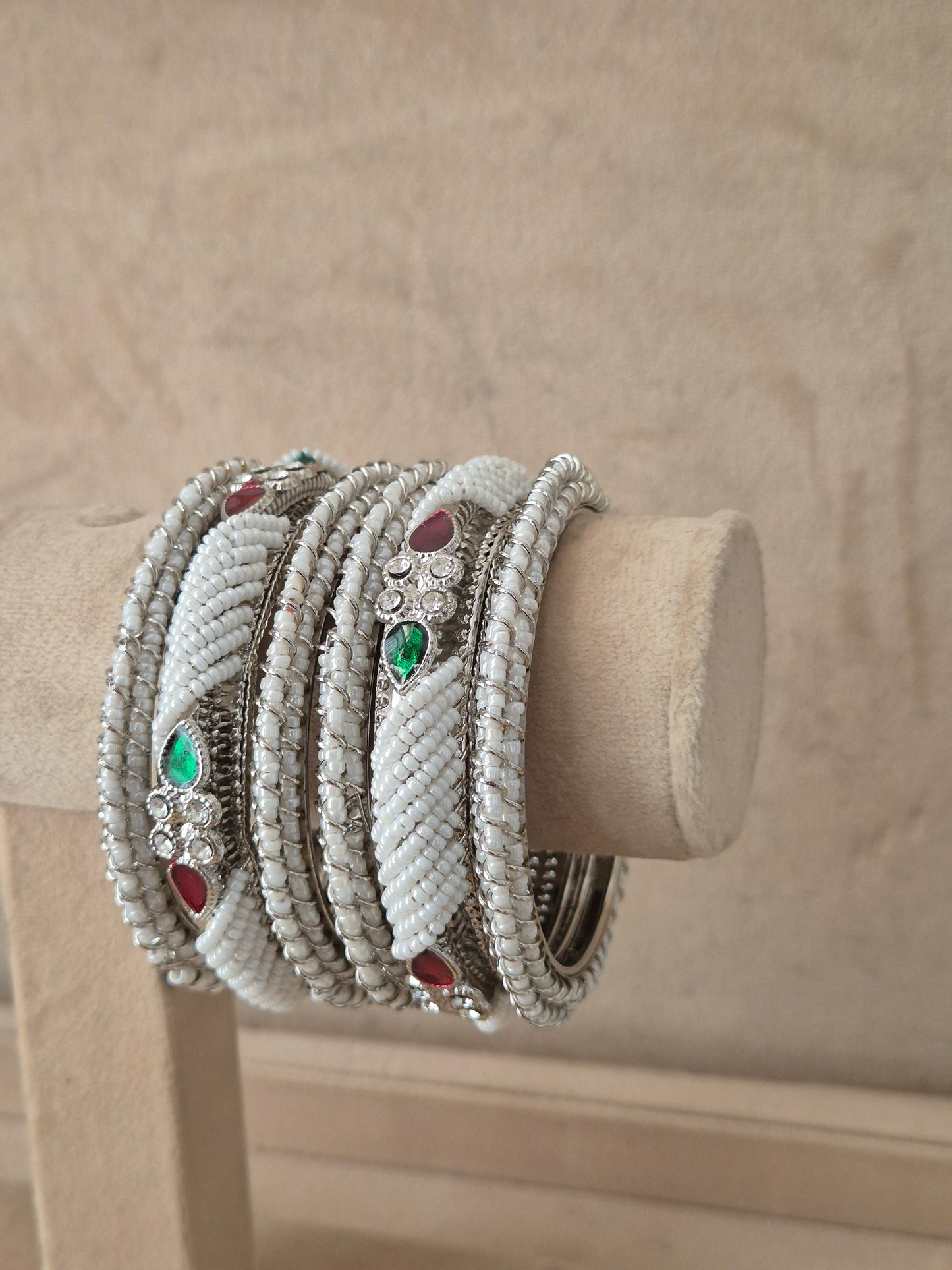 Traditional silver -plated bangles with a red gemstone accent and intricate cut-out patterns by naitri.in