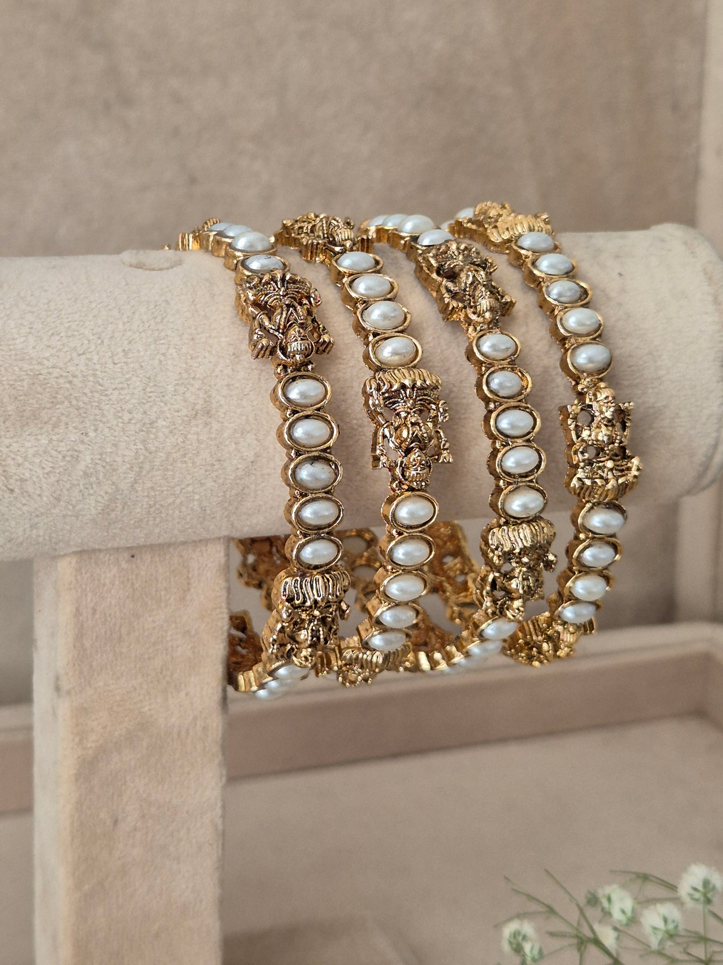 Antique gold bangles with delicate faux pearl embellishments and detailed traditional Indian craftwork by naitri.in