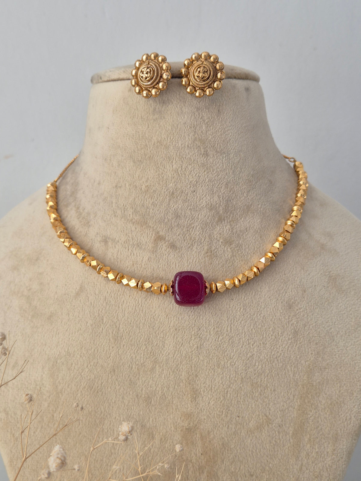 Ornate gold-toned fashion jewelry set with a detailed pendant design and matching earrings for ethnic wear by Naitri.in