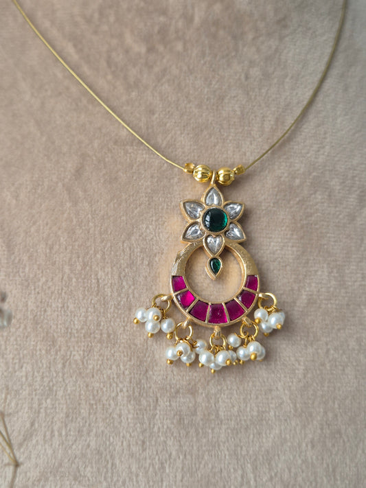 Modern Indian aesthetic invisible chain necklace with a traditional floral-motif crescent pendant in gold, pink, and green by naitri.in