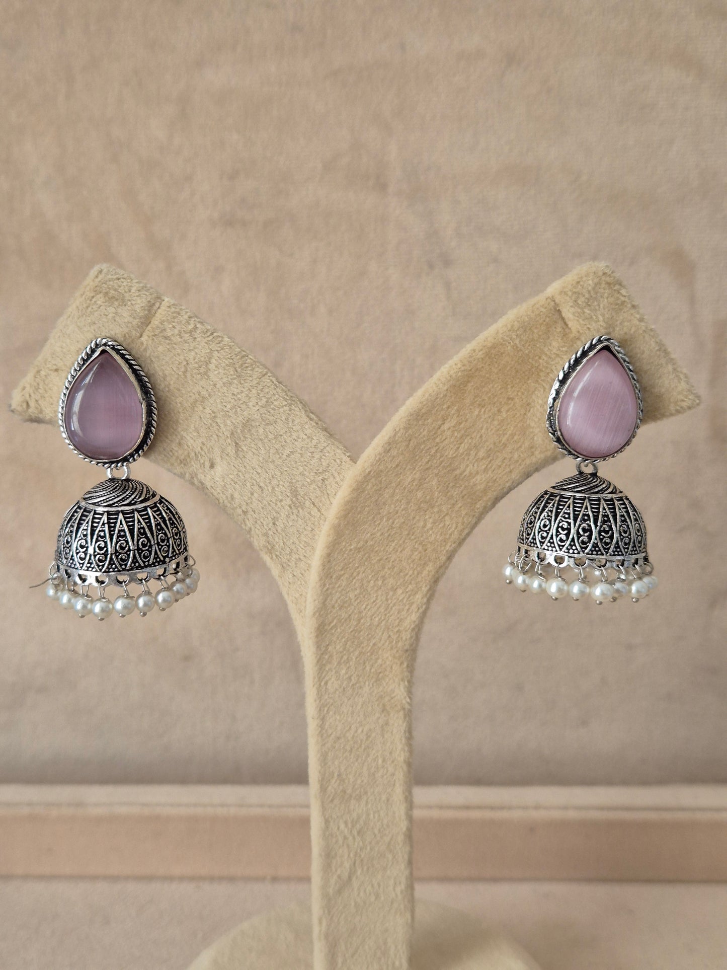 Silver imitation jewelry drop earrings featuring pink stone embellishments and Modern Indian aesthetic silver-plated geometric earrings featuring delicate pink stone details by naitri.in