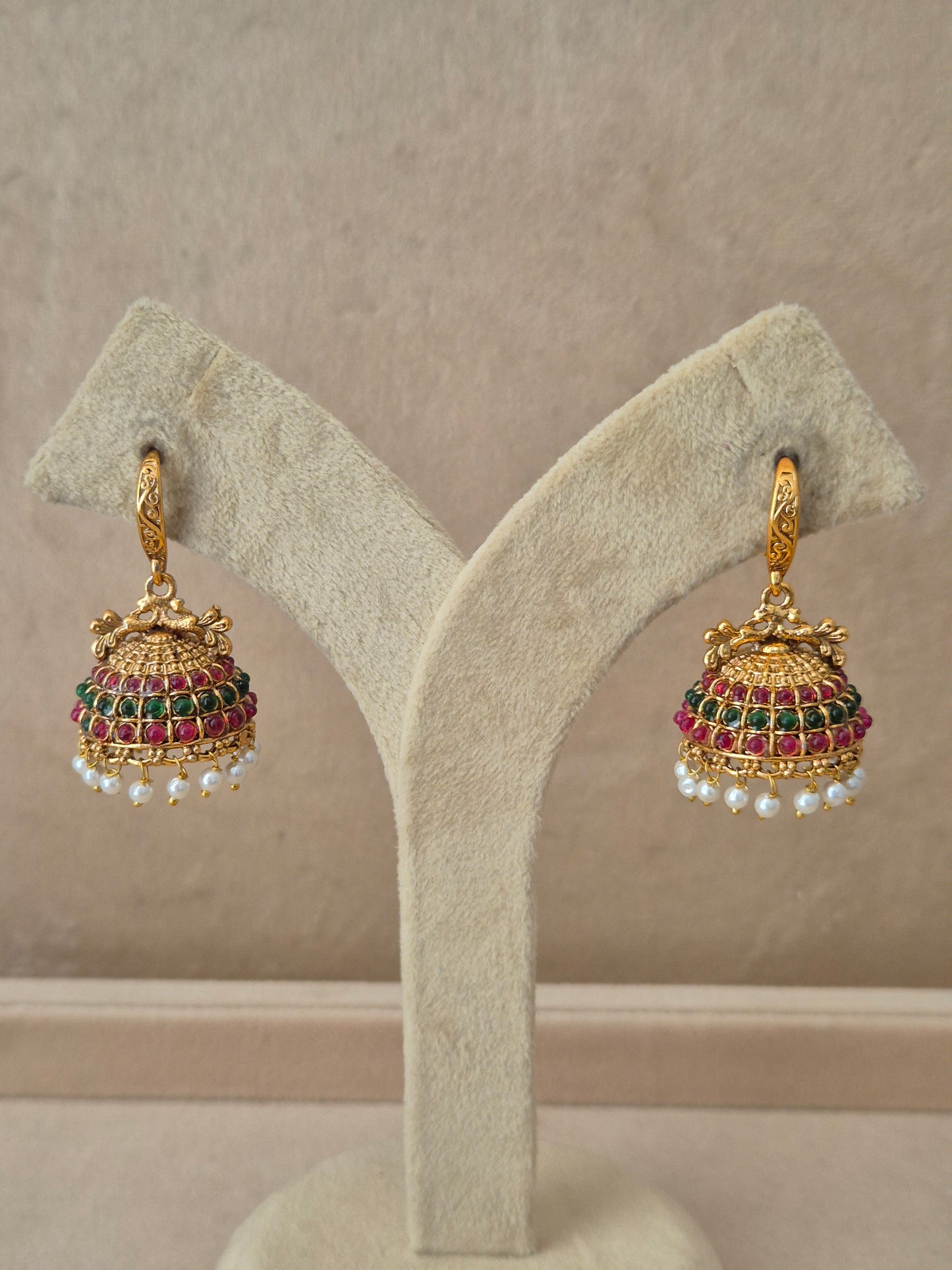 traditional gold-toned temple design Jhumka earrings with red and green stones and tiny white pearl drops by naitri.in