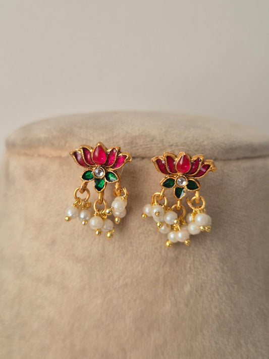 Pair of decorative earrings with pink and gold lotus design a small stone in middle of flower and some pearls hanging from flower by naitri.in