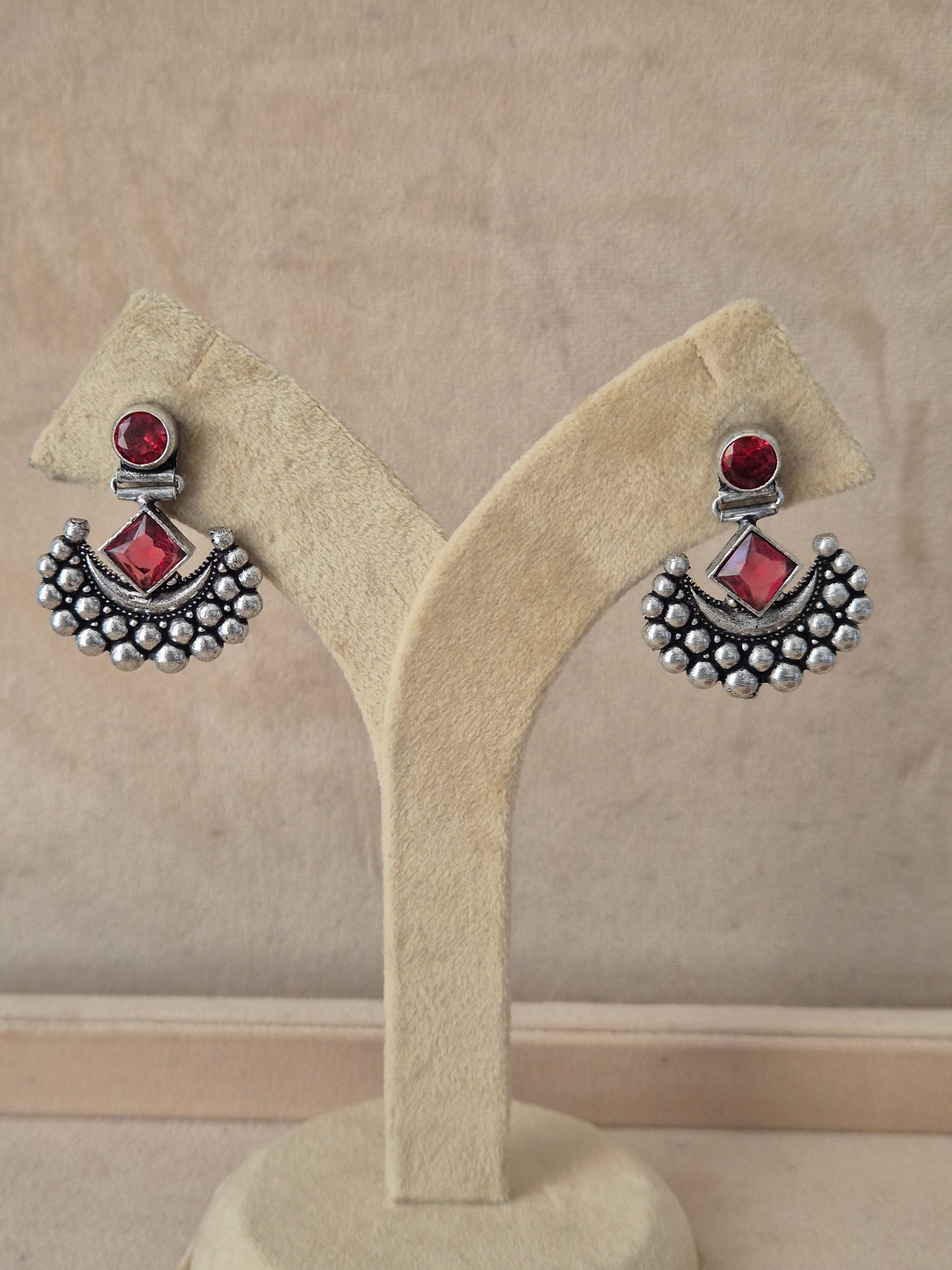 Handcrafted oxidized silver drop earrings with pinkish-red gemstone Modern Indian aesthetic silver-plated statement earrings featuring a vibrant red square-set stone and delicate metallic bead detailing by naitri.in