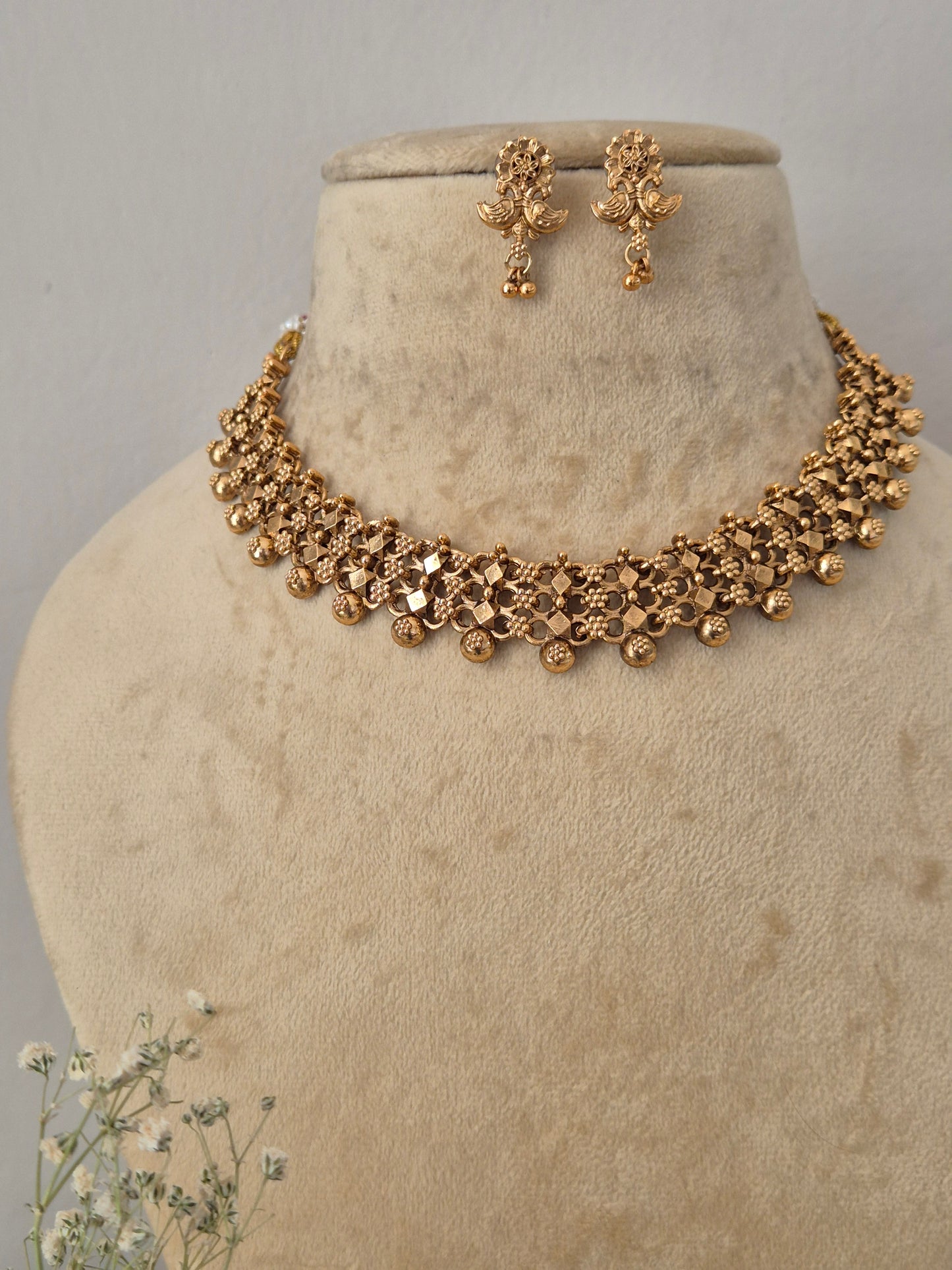 Necklace Set featuring an ethnic gold-plated choker and matching antique-style dangle earrings for festive wear by naitri.in