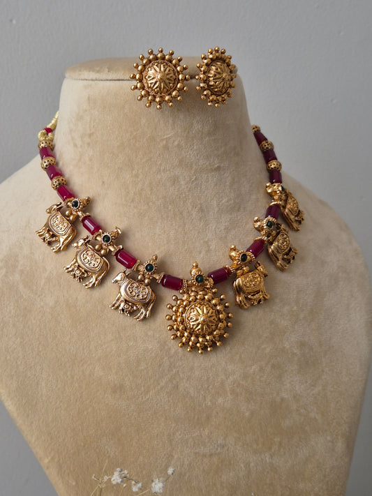 Traditional gold-plated choker with red stone accents and matching floral studs by naitri.in