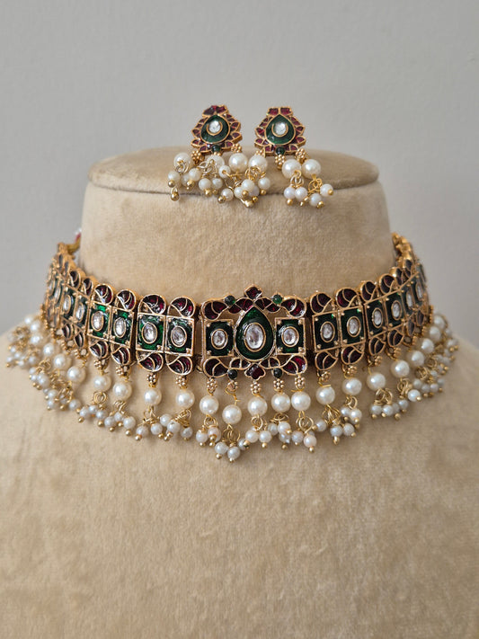 Intricate gold-finish ethnic jewelry set with floral stone motifs and delicate pearl hangings, perfect for festive and bridal wear by naitri.in