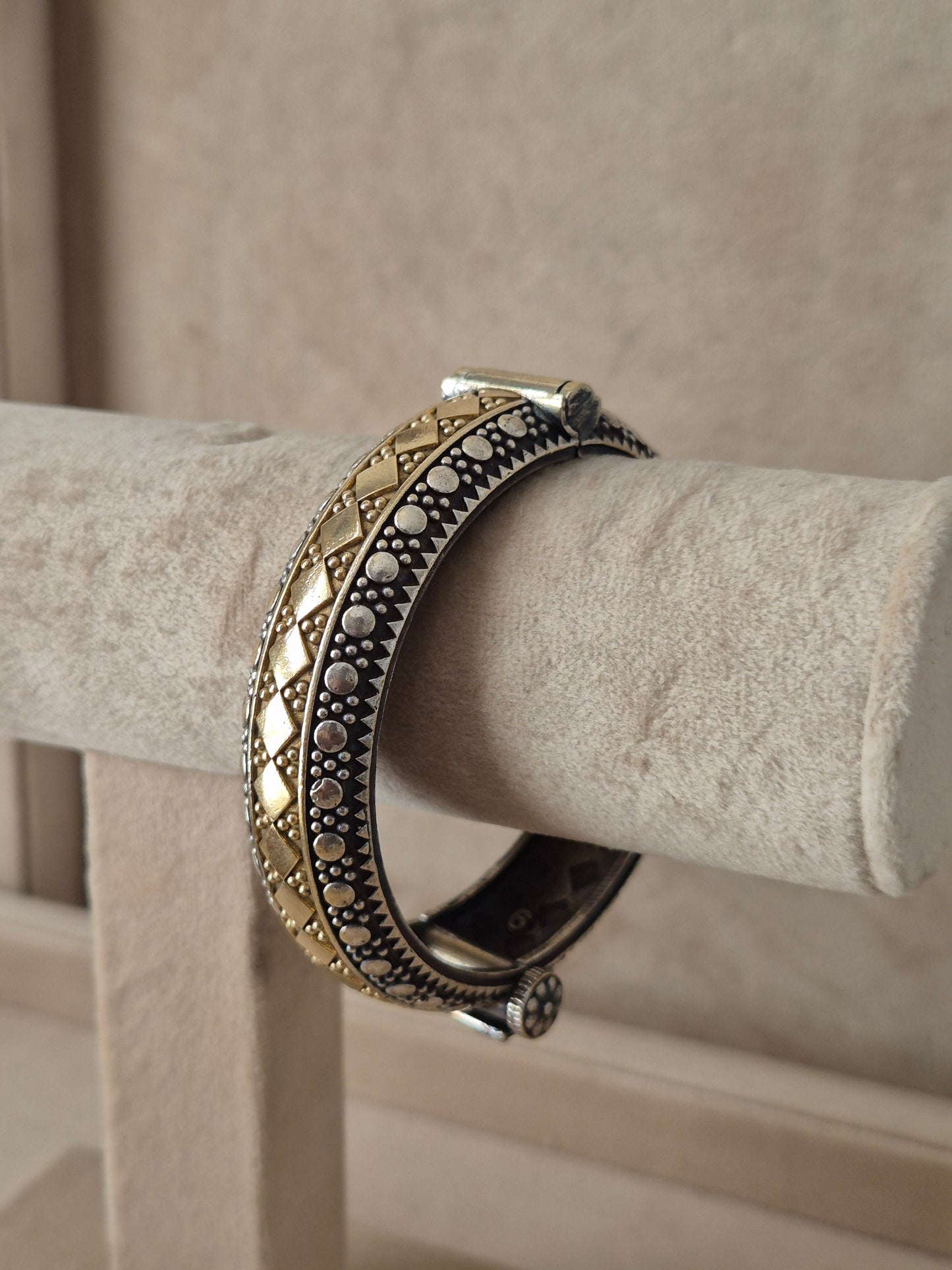 Festive style silver and gold textured bangle bracelet exhibited