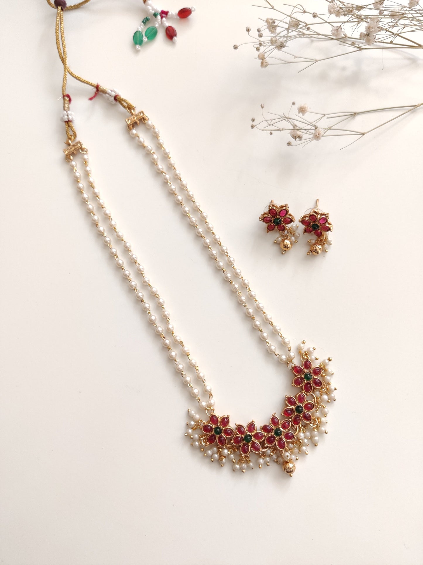 Artistic shot of temple necklace set featuring gold, green, and red embellishments and intricate metalwork