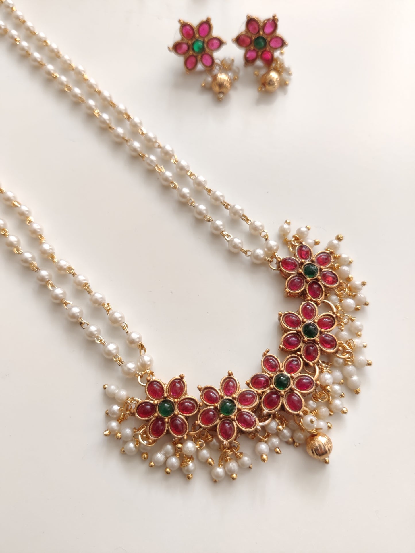 Artistic shot of temple necklace set featuring gold, green, and red embellishments and intricate metalwork