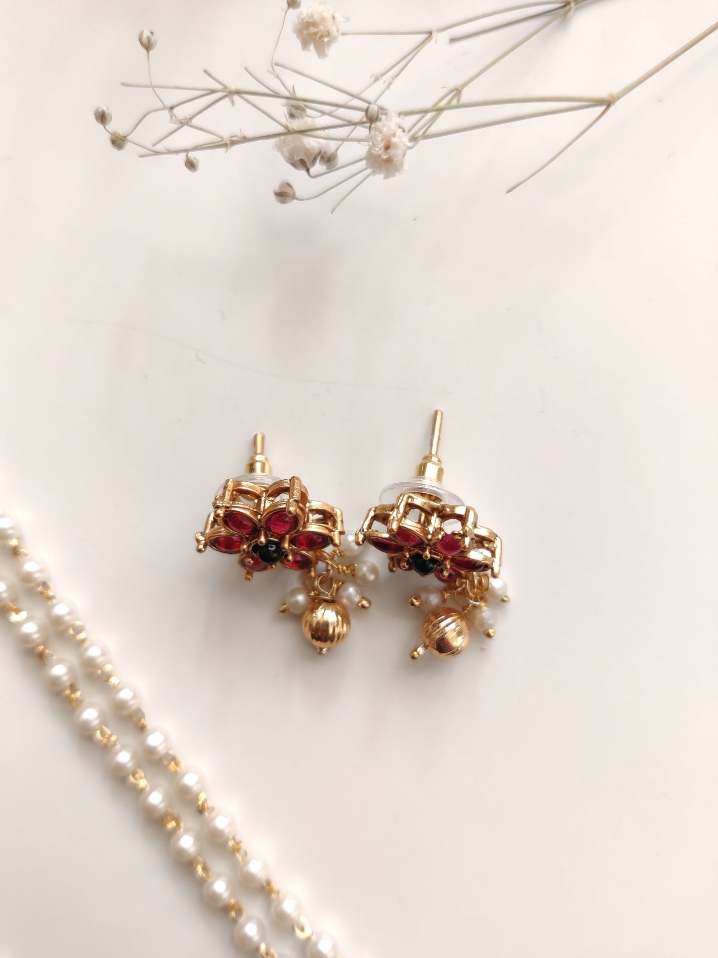 Artistic shot of temple necklace set featuring gold, green, and red embellishments and intricate metalwork