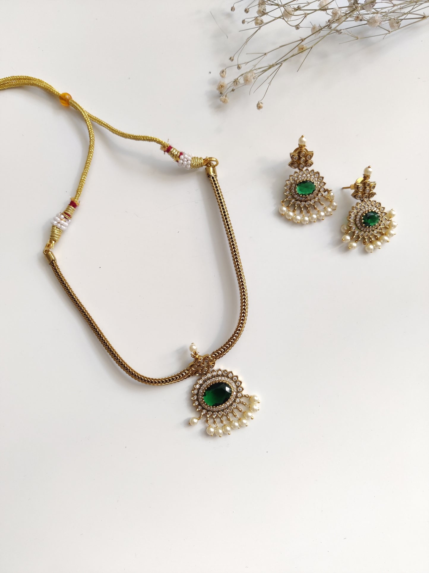 Elegant temple necklace with gold and green details, showcased with focus on delicate metalwork