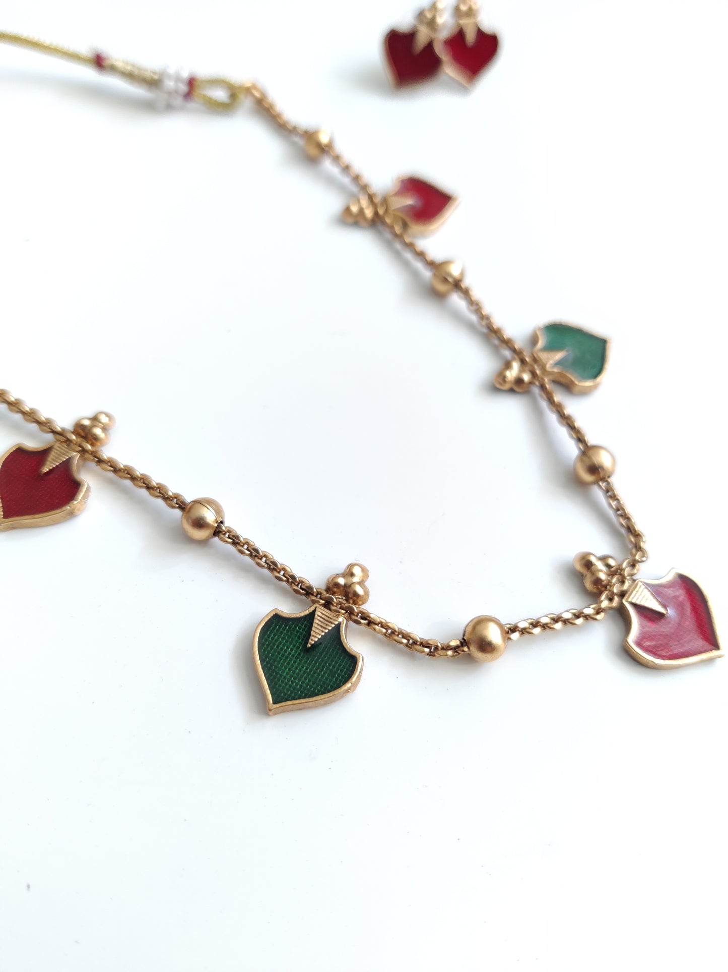 Luxurious temple necklace set with gold, red, and green highlights, draped to display fine artisan work