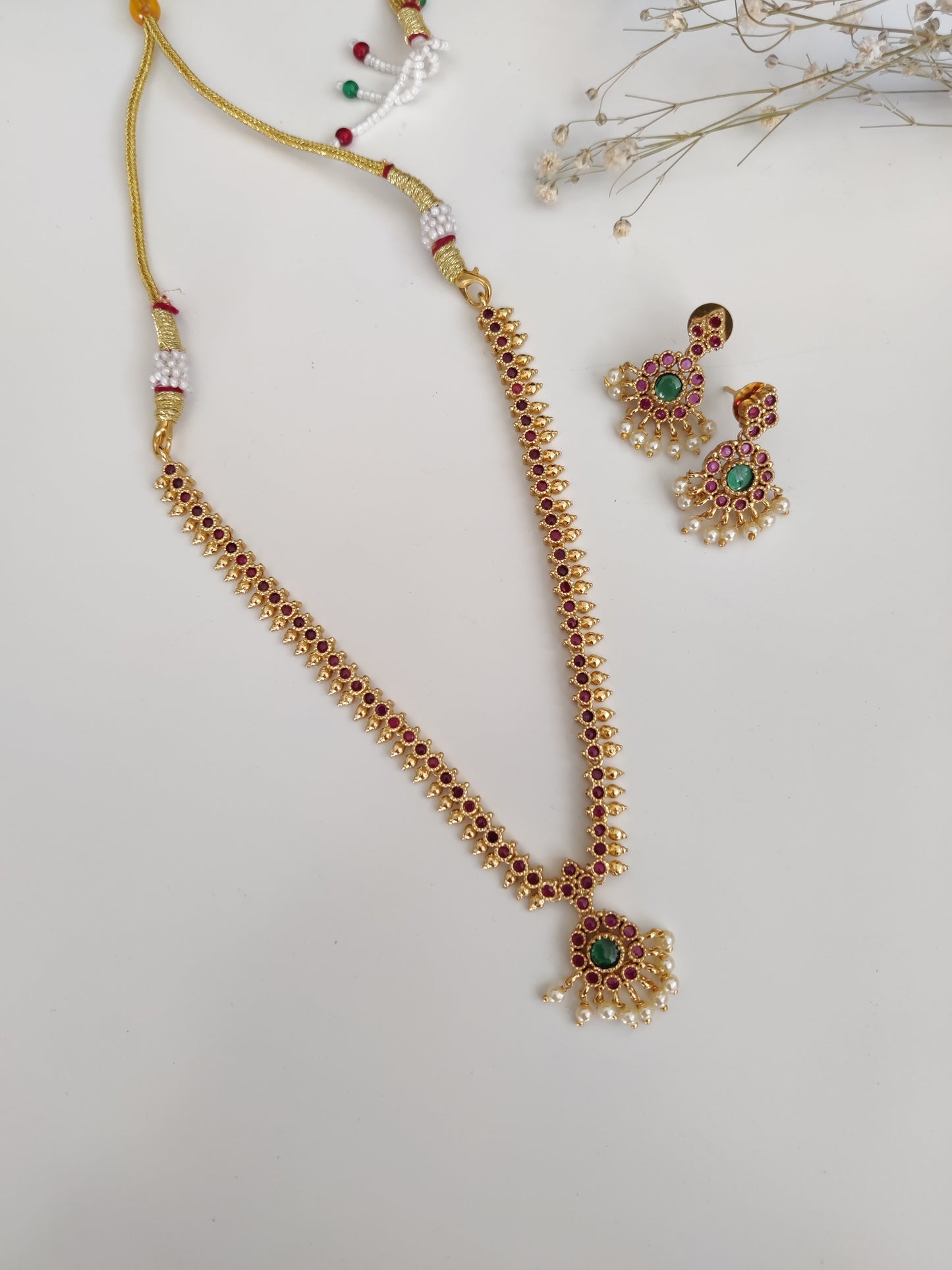 Sophisticated metal alloy necklace set photographed on a plain background to show classic design