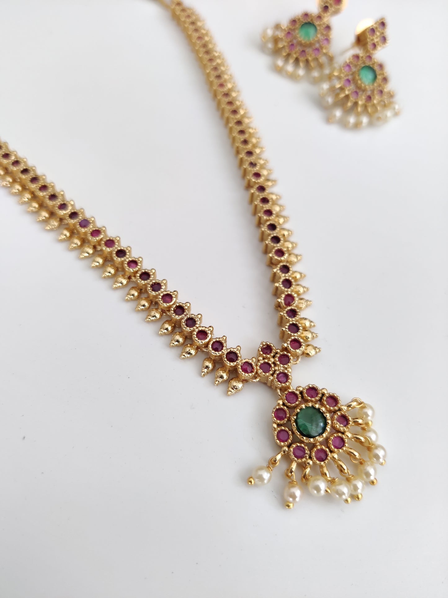Sophisticated metal alloy necklace set photographed on a plain background to show classic design