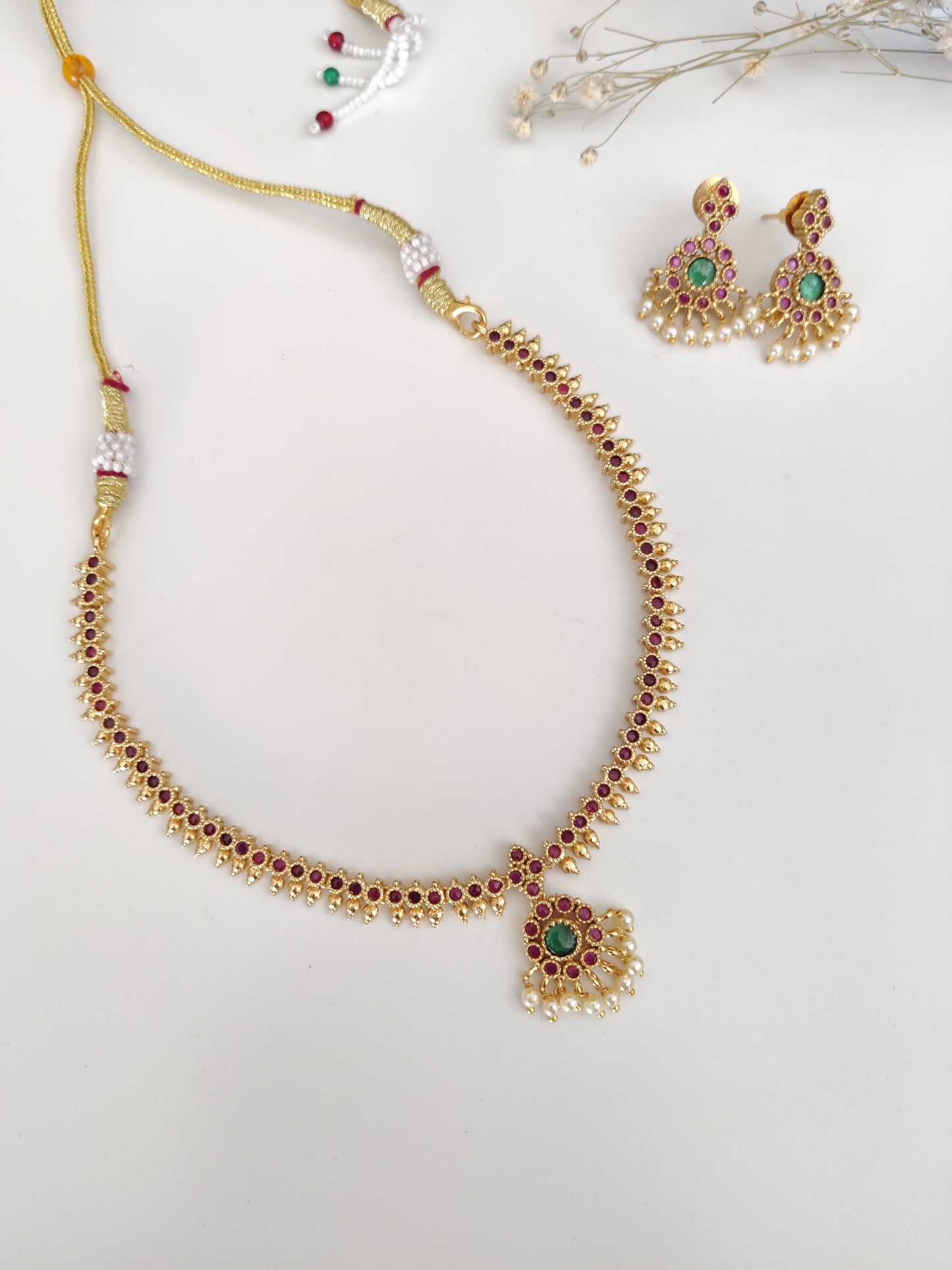 Sophisticated metal alloy necklace set photographed on a plain background to show classic design