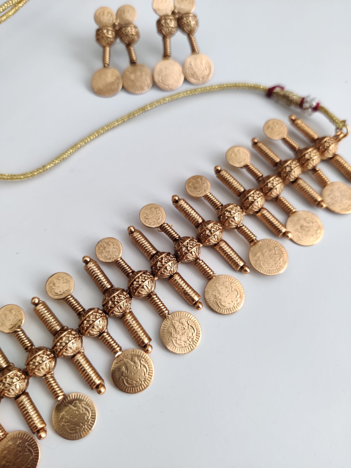 Refined temple necklace set in metal alloy with gold accents, displayed to showcase intricate detailing