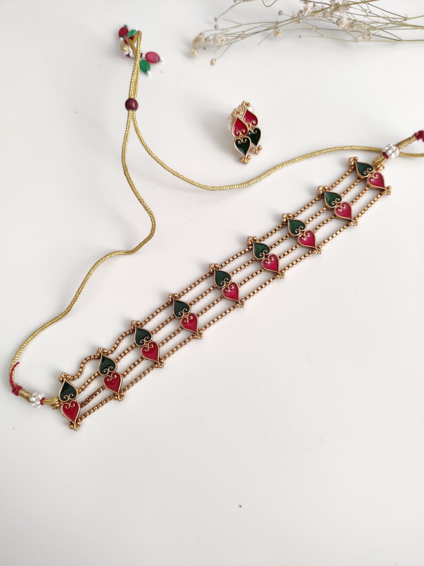 Elegant temple choker set detailed with gold, red, and green tones, shown on a neutral background
