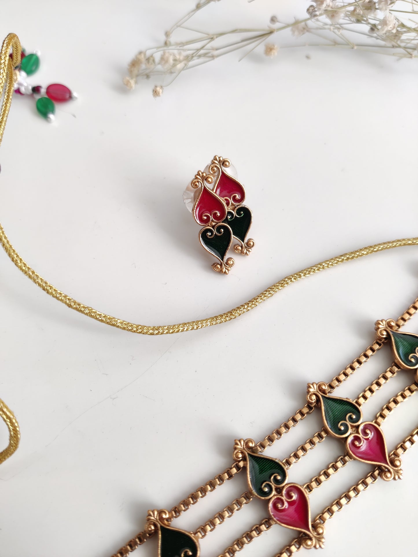 Elegant temple choker set detailed with gold, red, and green tones, shown on a neutral background