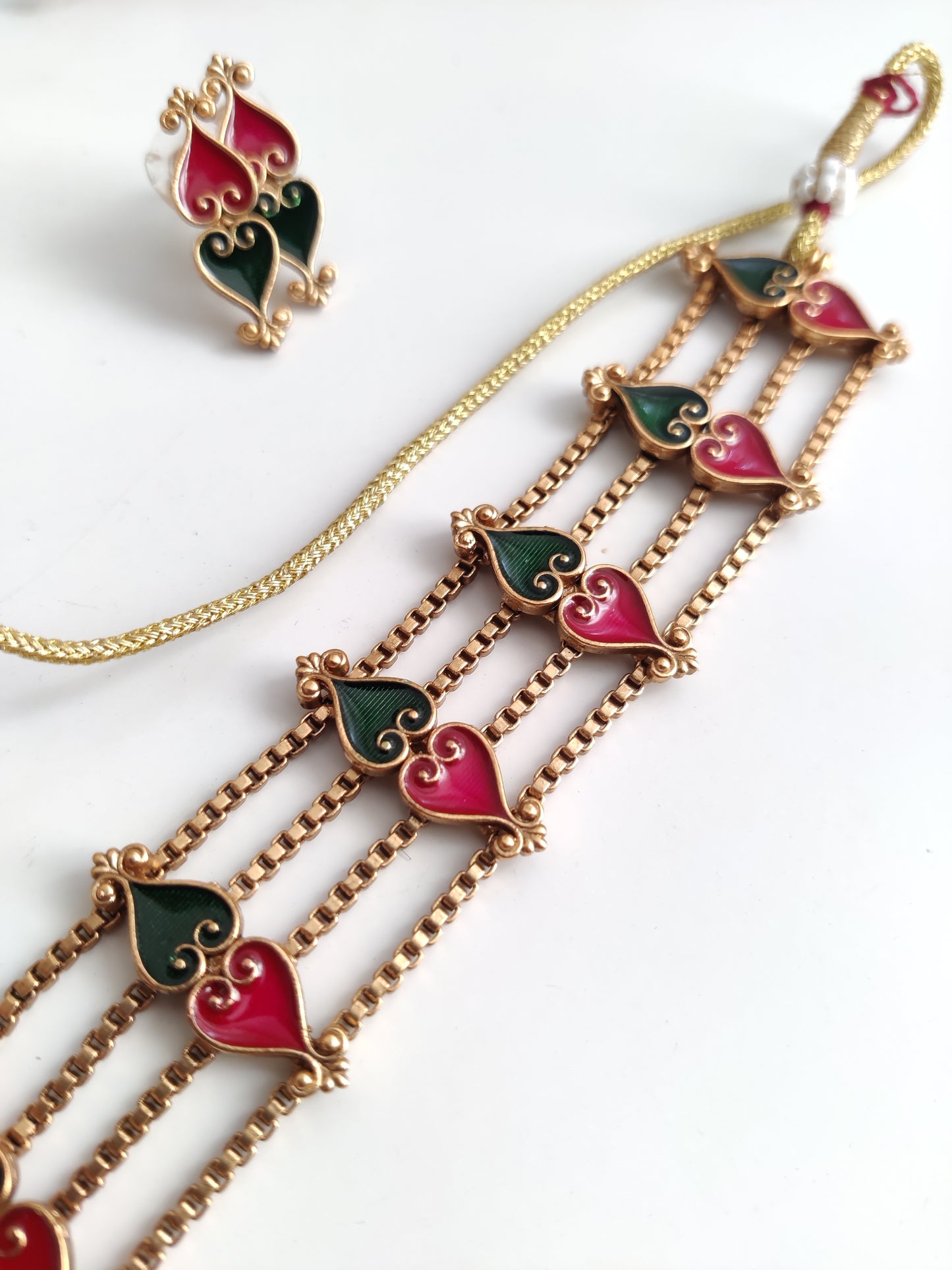 Elegant temple choker set detailed with gold, red, and green tones, shown on a neutral background