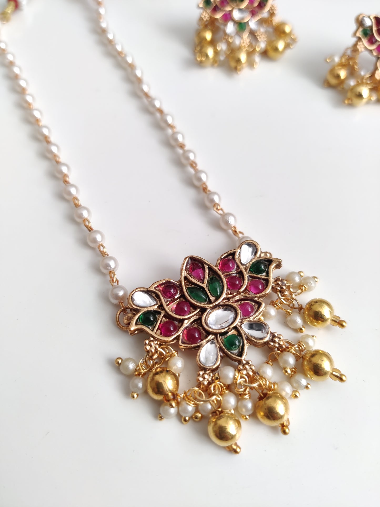 Temple necklace set with stud and dangle elements in gold-tone metal alloy, emphasizing detailed craftsmanship