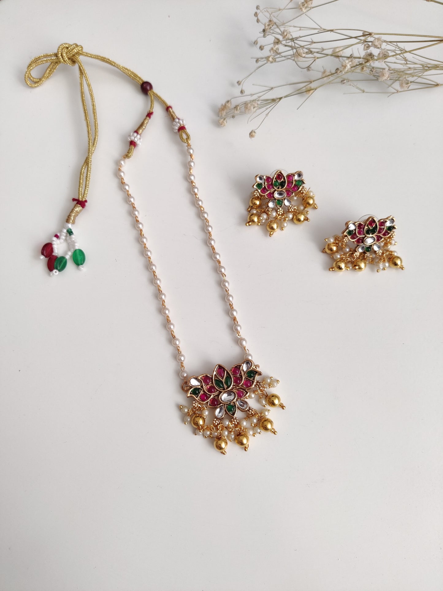 Temple necklace set with stud and dangle elements in gold-tone metal alloy, emphasizing detailed craftsmanship