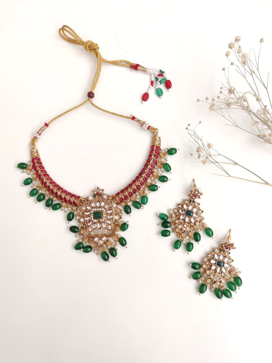 Premium temple necklace set with rich gold, green, and red details photographed on neutral background